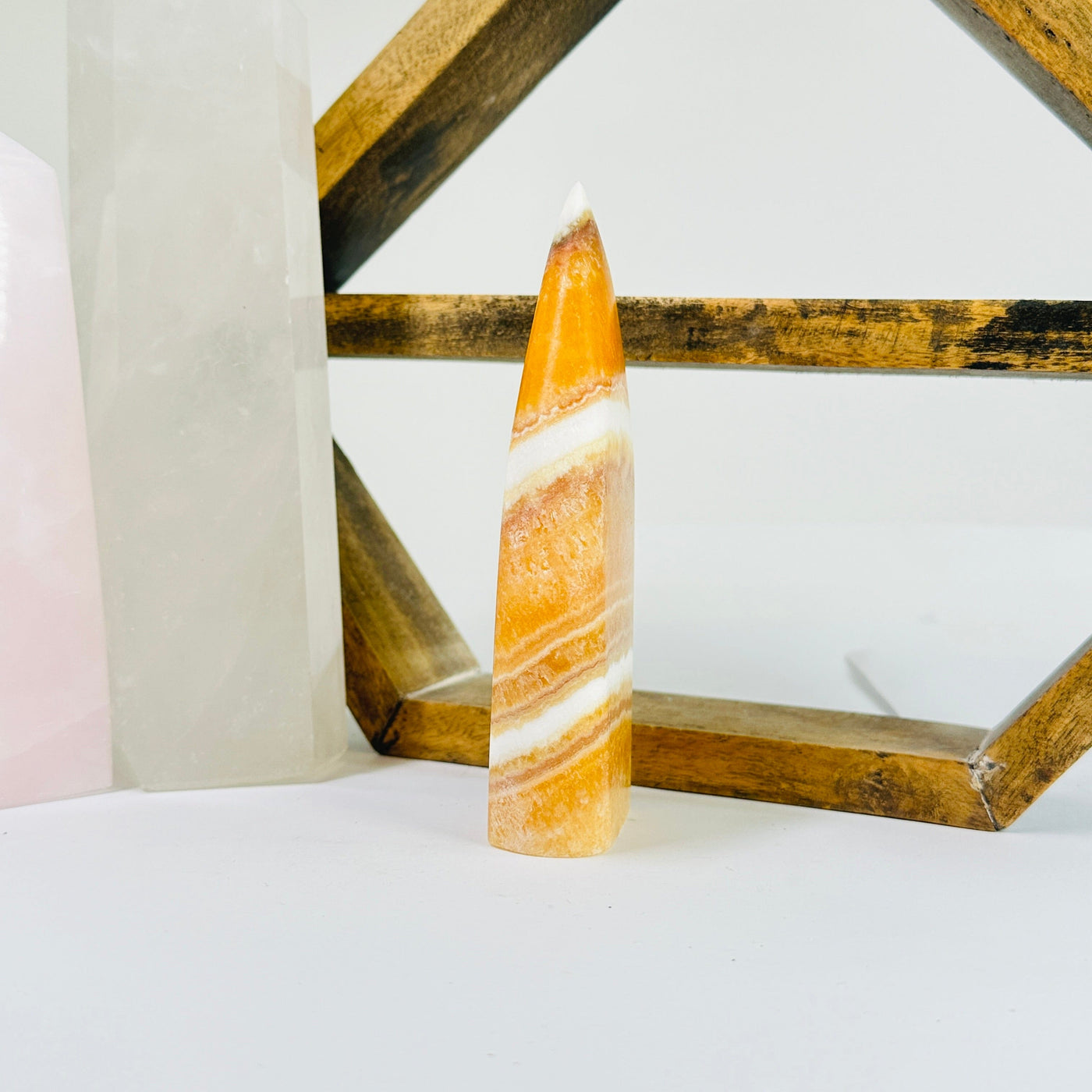 BANDED CALCITE POint with decorations in the background