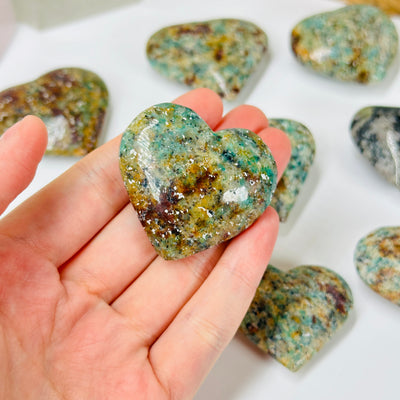 amazonite heart with decorations in  the background