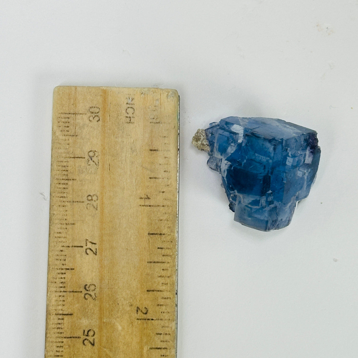 blue fluorite next to a ruler for size reference