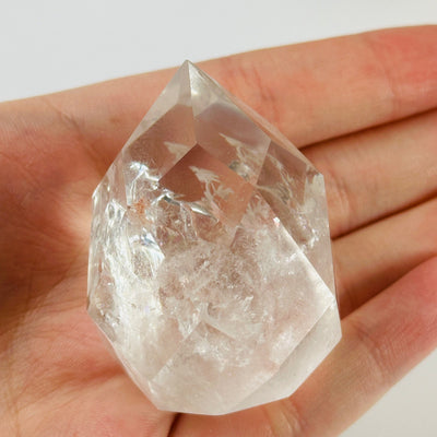 crystal quartz point with decorations in the background