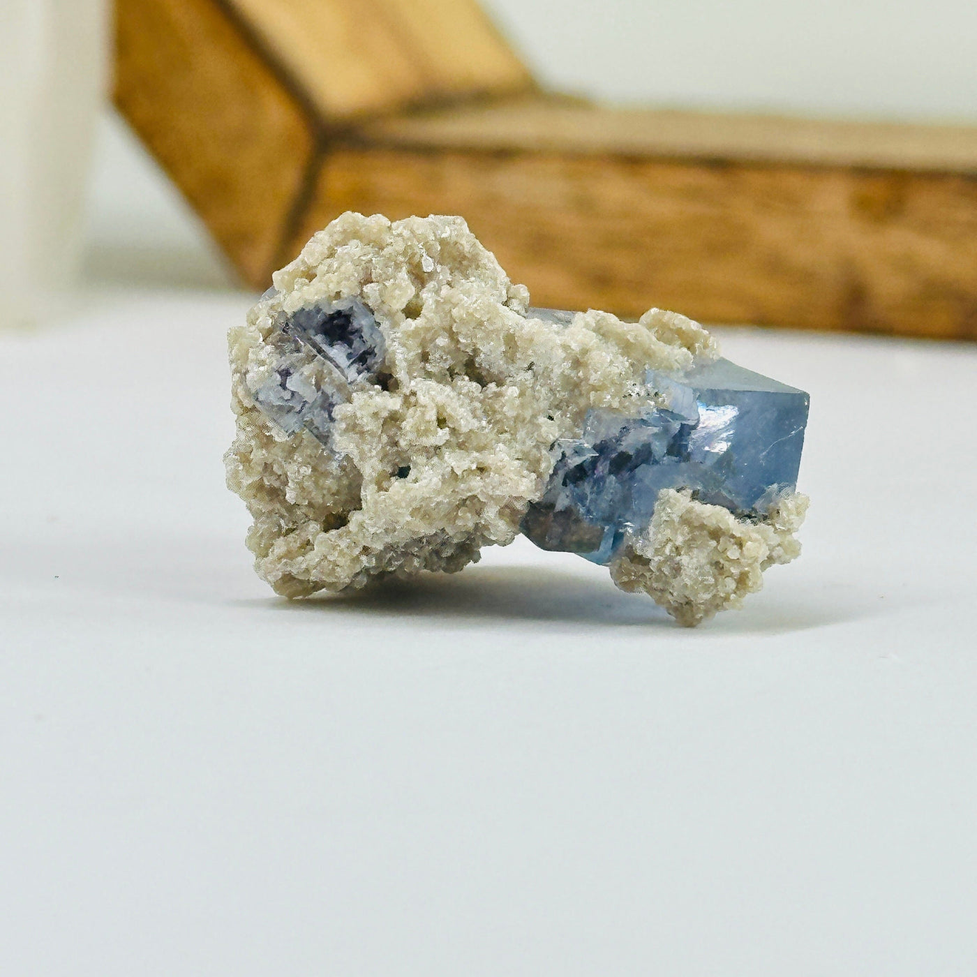 Blue fluorite crystal with decorations in the background