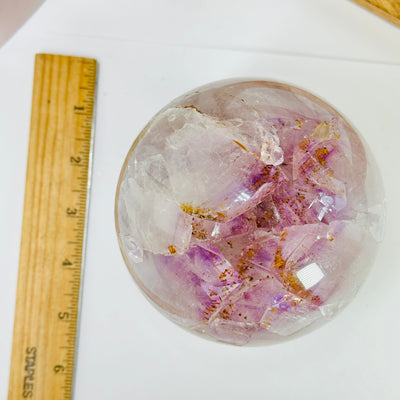 amethyst sphere next to a ruler for size reference