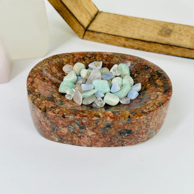 feldspar and tourmaline bowl with decorations in the background