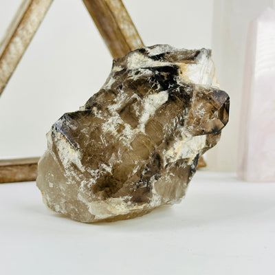 alligator smokey quartz cluster with decorations in the background