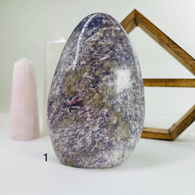 lepidolite cut base with decorations in the background