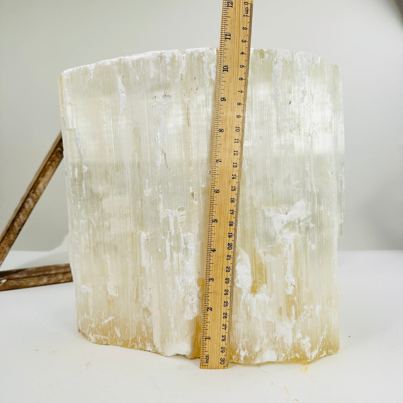 selenite cluster next to a ruler for size reference
