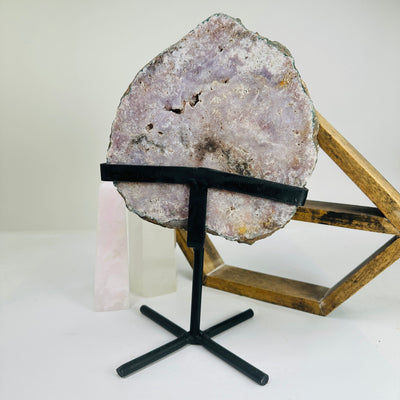 pink amethyst on metal stand with decorations in the background