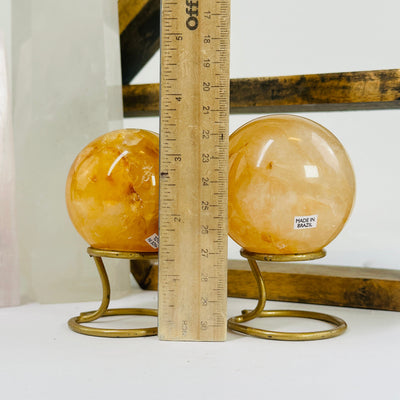 golden healer sphere next to a ruler for size reference