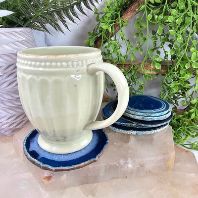 Agate Slice Set - Set of Six Blue Agate Crystal Coasters one slice being used as a coaster for a cup with other slices in the background