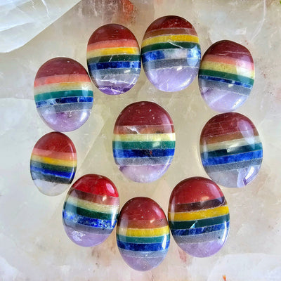 Seven Chakra Worry Stone 10 rainbow colored stones arranged in a circle with one in the middle on quartz platter