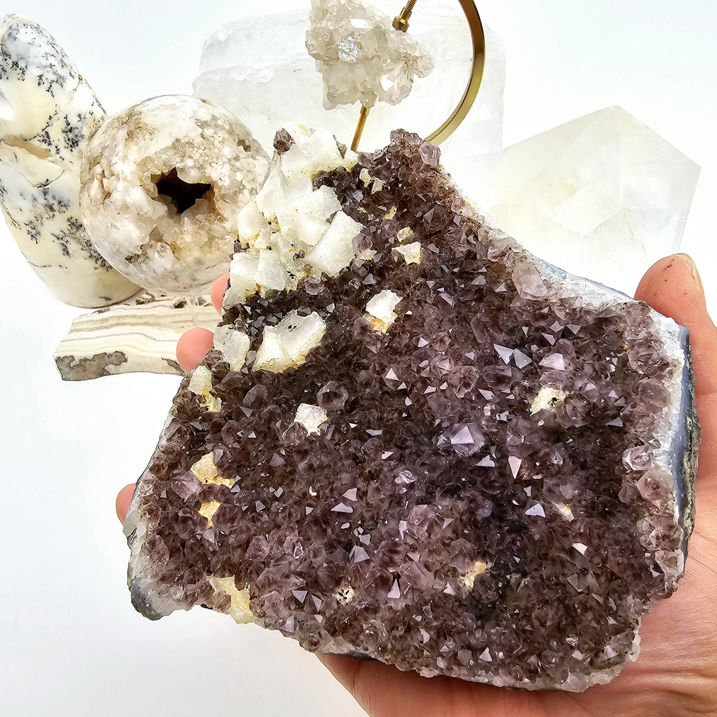 Amethyst Cluster with Calcite 1 in hand for size reference with props in the background