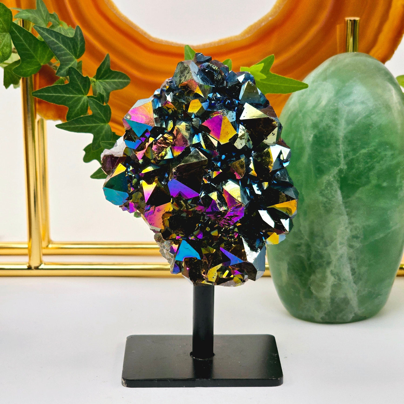 Titanium Coated Amethyst Cluster on Stand 2 front view with props in background