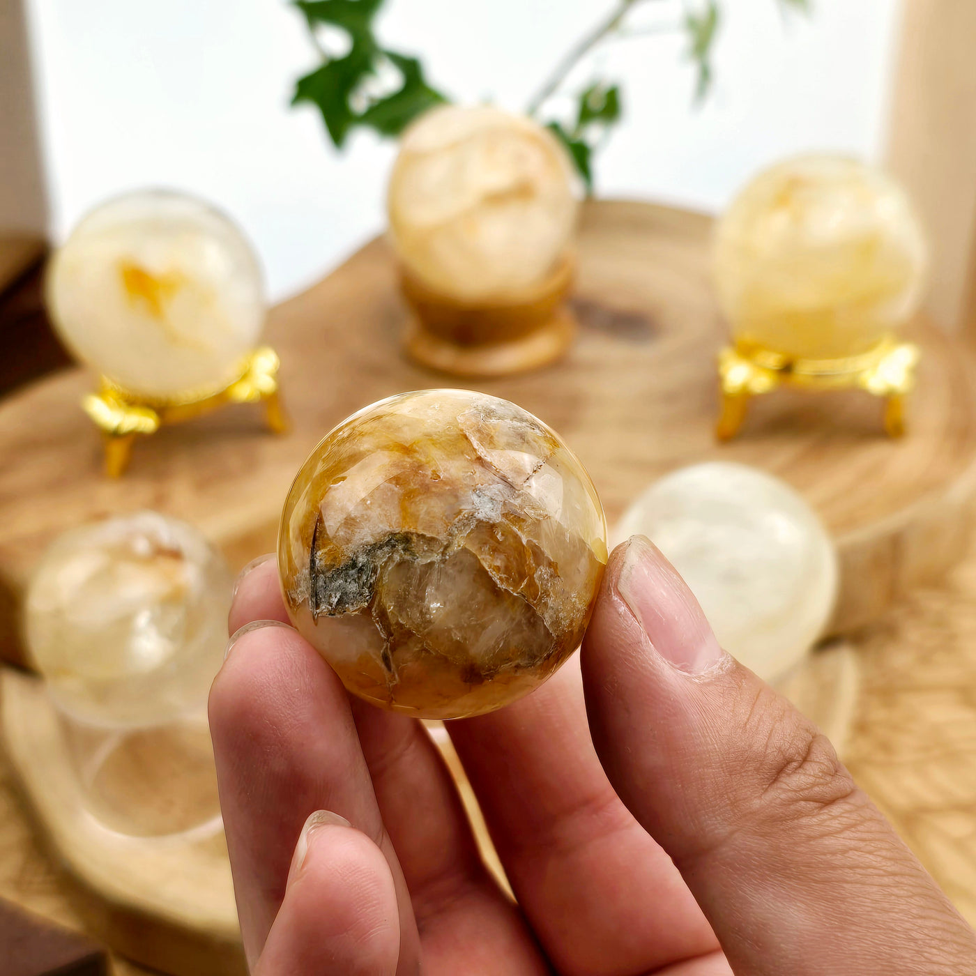 Golden Healer Sphere - You Choose in hand for size reference with other spheres in the background