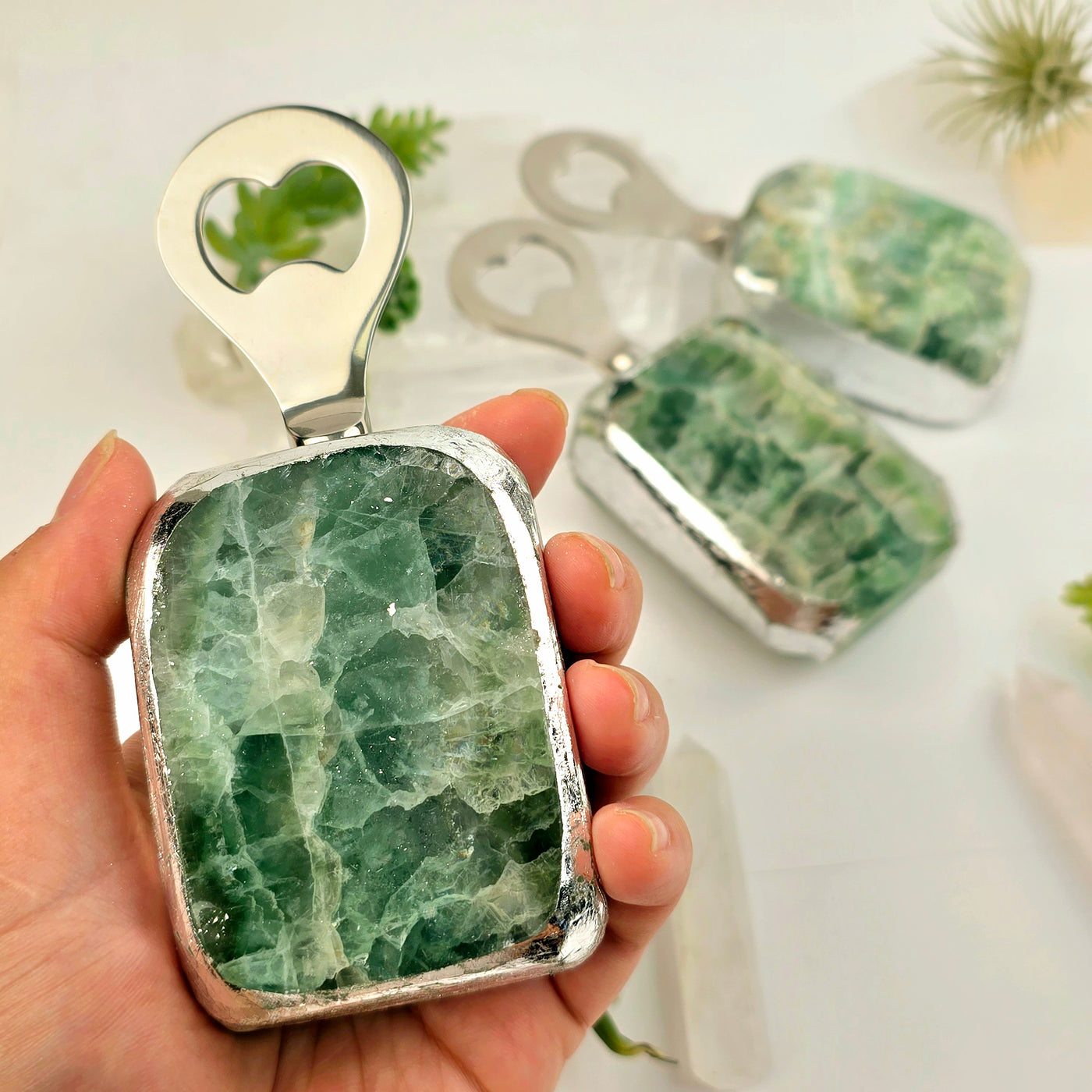 Green Fluorite Bottle Opener - in hand for size reference with other bottle openers in the background