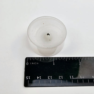 votive candle with ruler for size reference