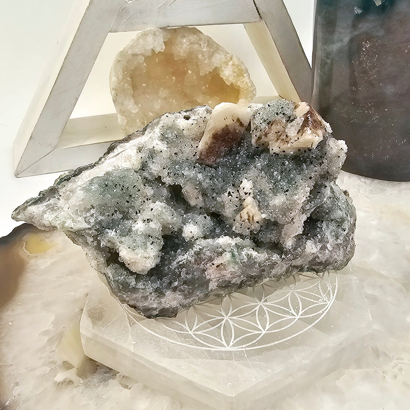 Chlorite Crystal Quartz Cluster #2 front view on coaster with props in the background