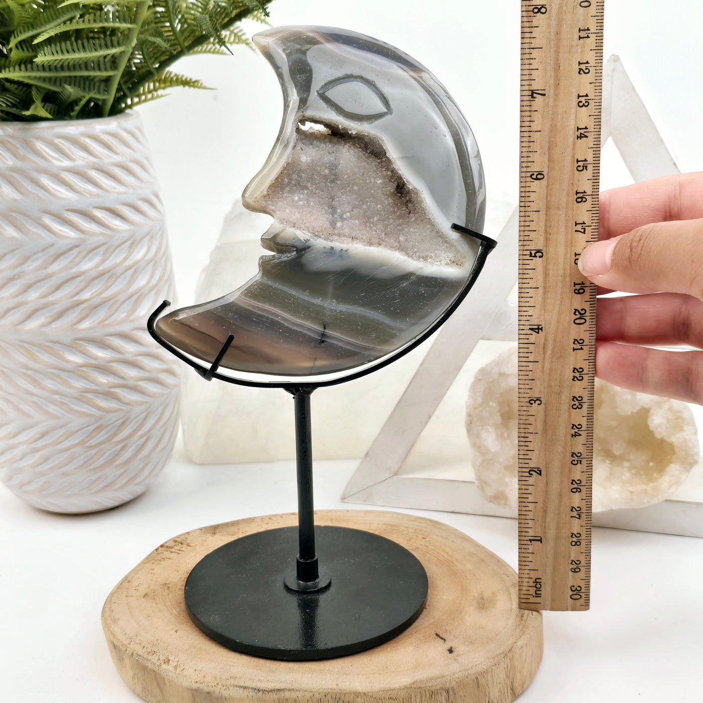 Agate Crystal Moon Carving on Metal Stand front view with ruler and hand for size reference