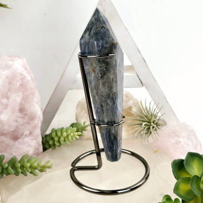 Blue Kyanite Crystal Wand on Stand #3 side view with props and plants in the background