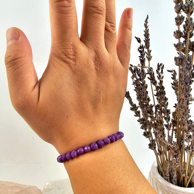 Phosphosiderite Faceted Round Bead Bracelet - 6mm on wrist with plant in background