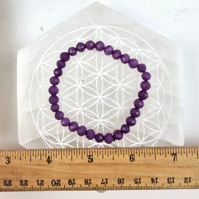 Phosphosiderite Faceted Round Bead Bracelet - 6mm on selenite flower of life dish with ruler for size reference