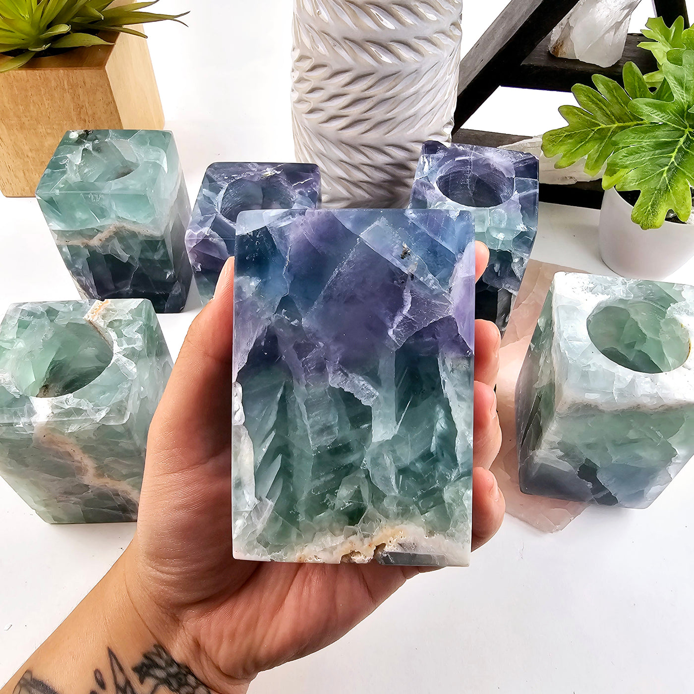 Fluorite Crystal Candle Holder - AA Grade one in hand for size reference with other candle holders in the background