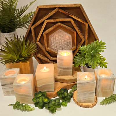 Mexican Onyx Rectangular Crystal Candle Holder candles lit with bright background with plants and props in the background