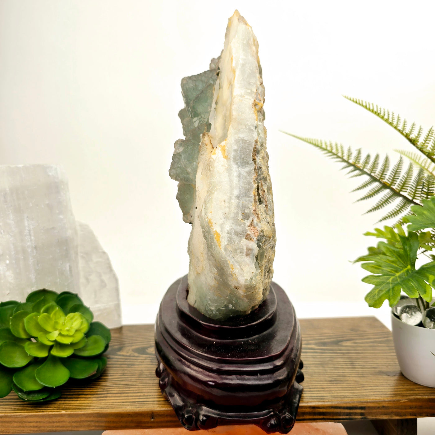 Large Cubic Fluorite Crystals on Matrix with Wooden Stand - Rare Find side view with plants and props in the background