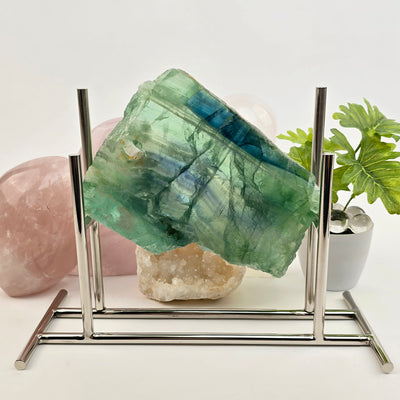 Green Fluorite Crystal Slab - One-of-a-Kind on stand with props and plants in the background