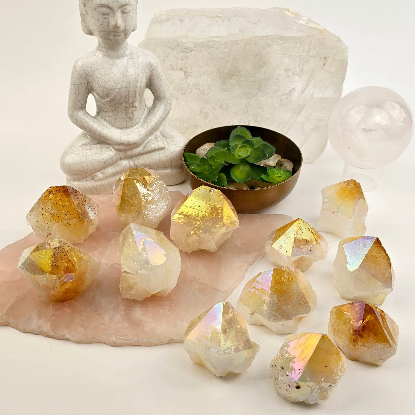 Angel Aura Citrine Semi Polished Crystal Point - By Weight both variants on stone platter and paper with props and plants in the background