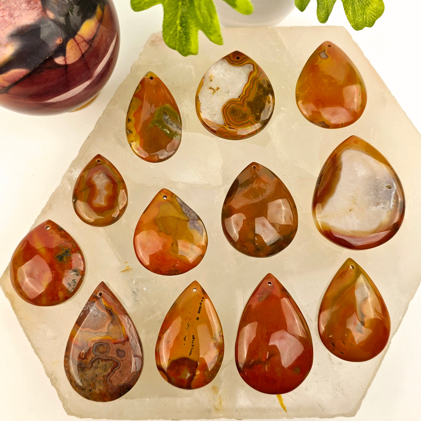 Carnelian Teardrop Crystal Pendant - You Choose top view all pendants on stone platter