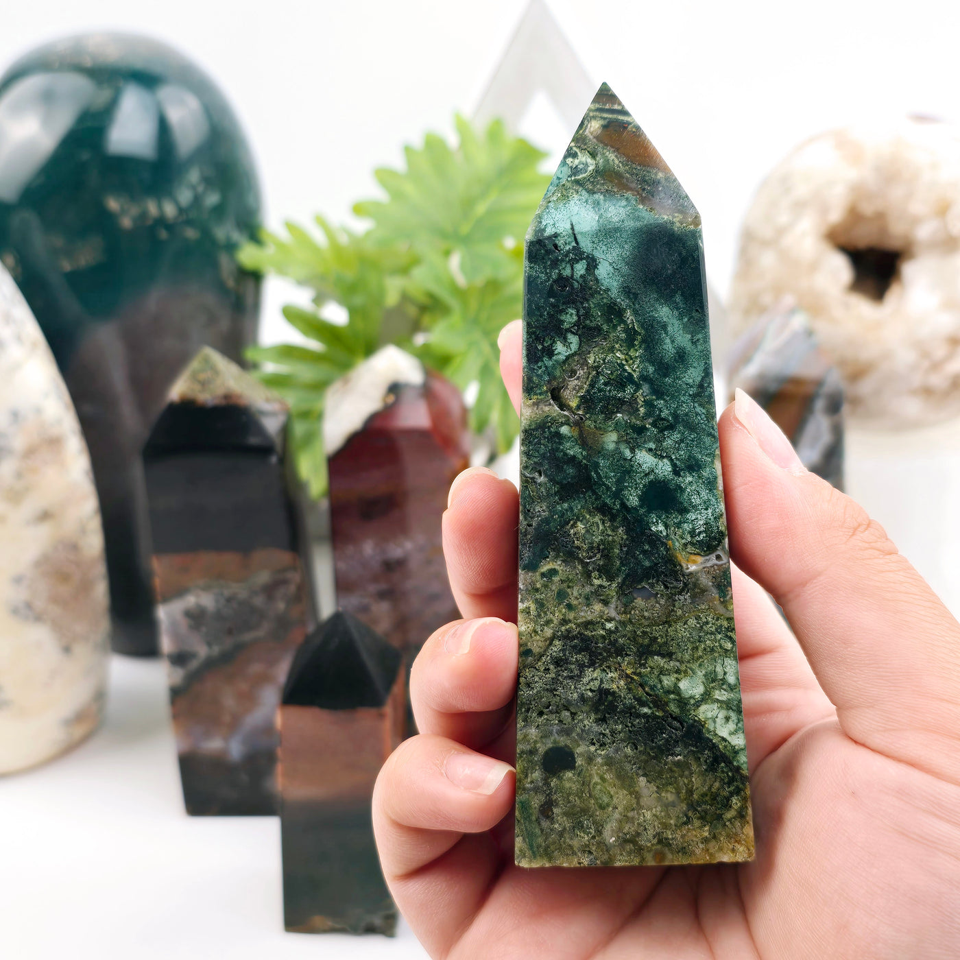 Ocean Jasper Polished Tower - You Choose - variant 4 in hand with other variants in the background with props and plants