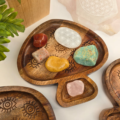 Mango Wood Evil Eye Mushroom Tray storing tumbled stones with props and plants in the background