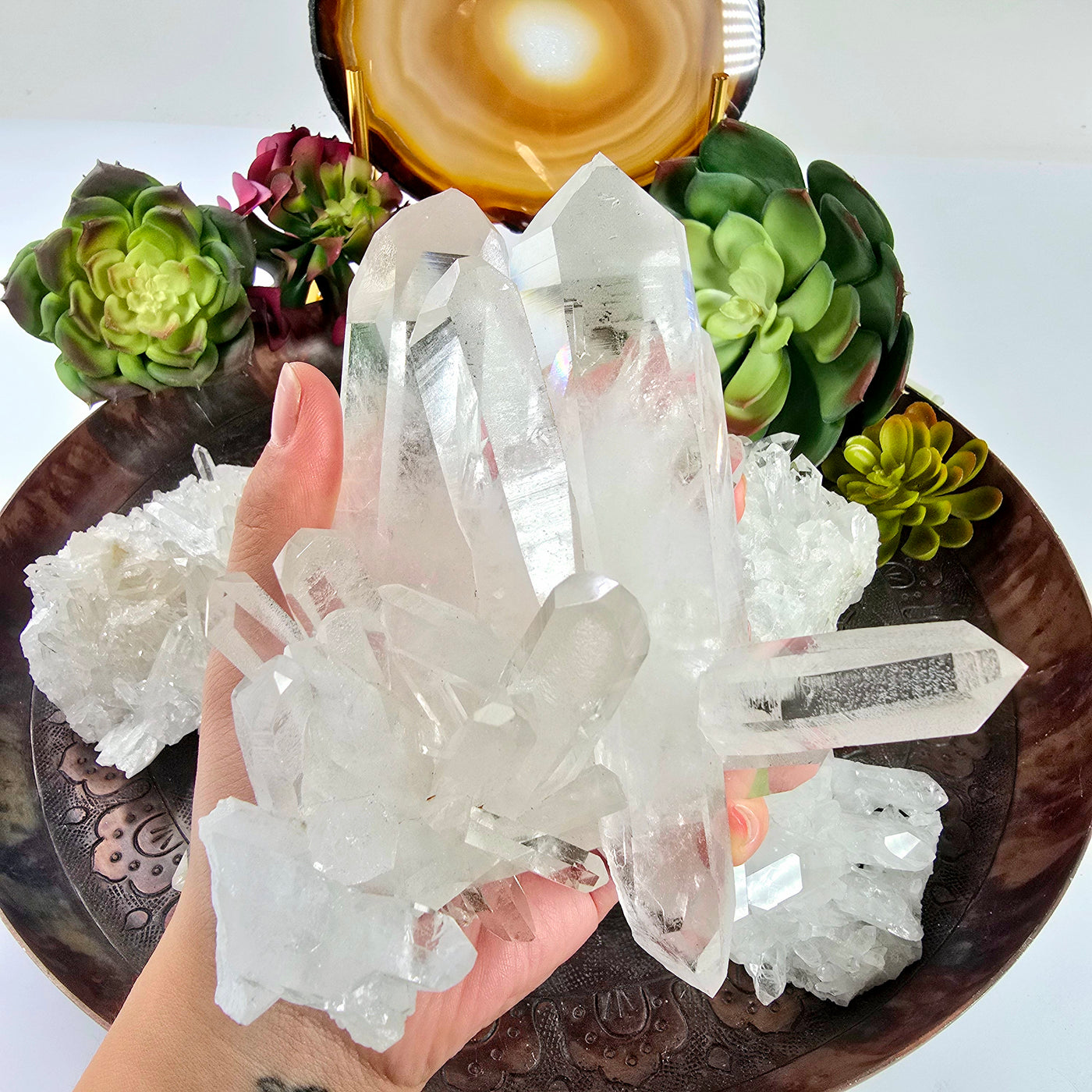 Crystal Quartz Cluster - AA Grade - You Choose from Brazil Top Quality - variant C in hand for size reference with other variants in the background with props and plants