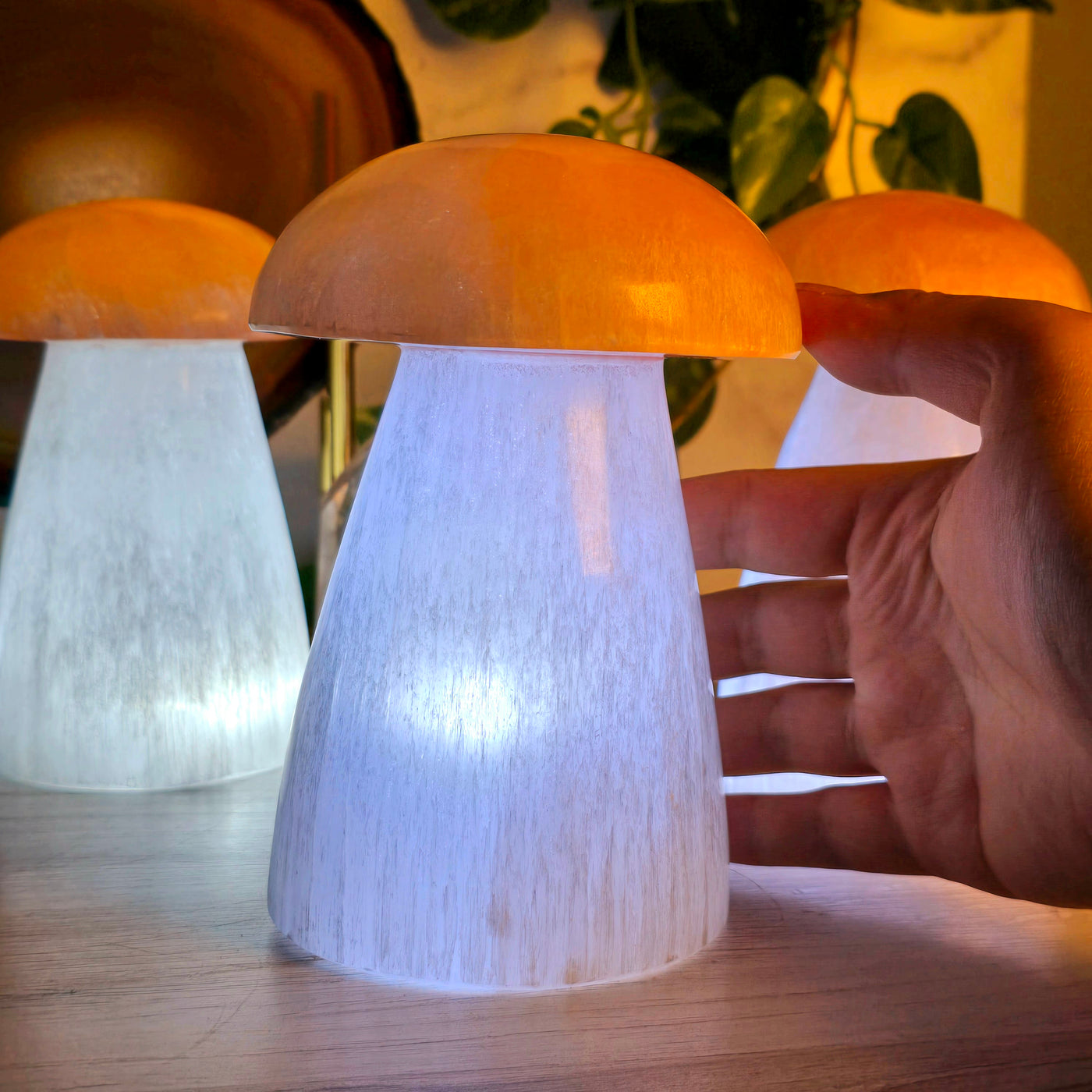 Selenite Mushroom Lamp - glowing lit mushroom lamp with hand for size reference