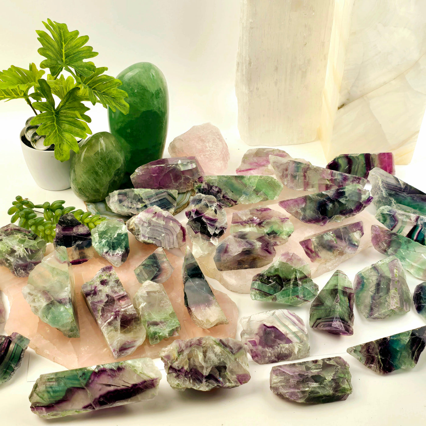  Rainbow Fluorite Small AA Grade Semi Polished Crystal Slab - You Choose all variants on stone platters and white table with props and plants in the background