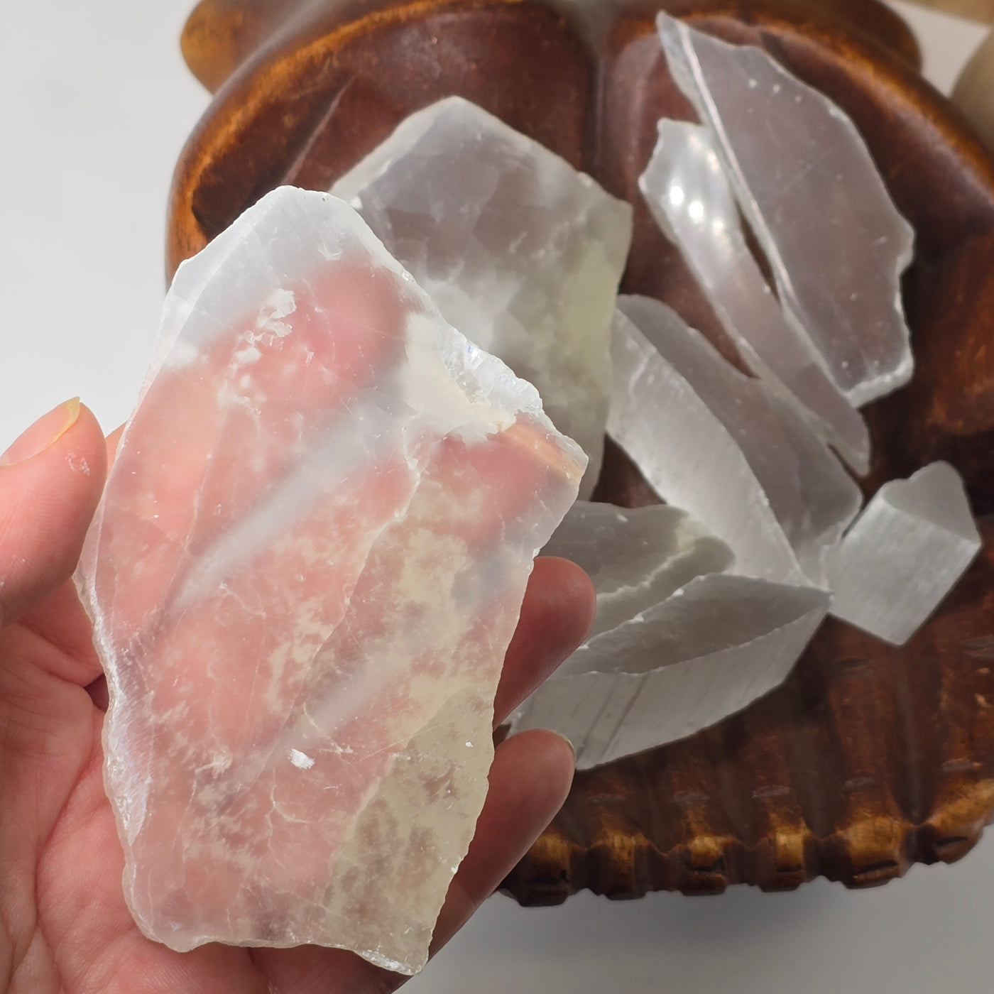 Optical Selenite Crystal Slabs - You Get All one slab in hand to show clarity with other slabs in wooden hands offering bowl