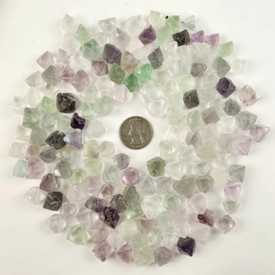 Fluorite Crystal Octahedrons - By the Pound - one pound of fluorite octahedrons shown with quarter for size reference on white background