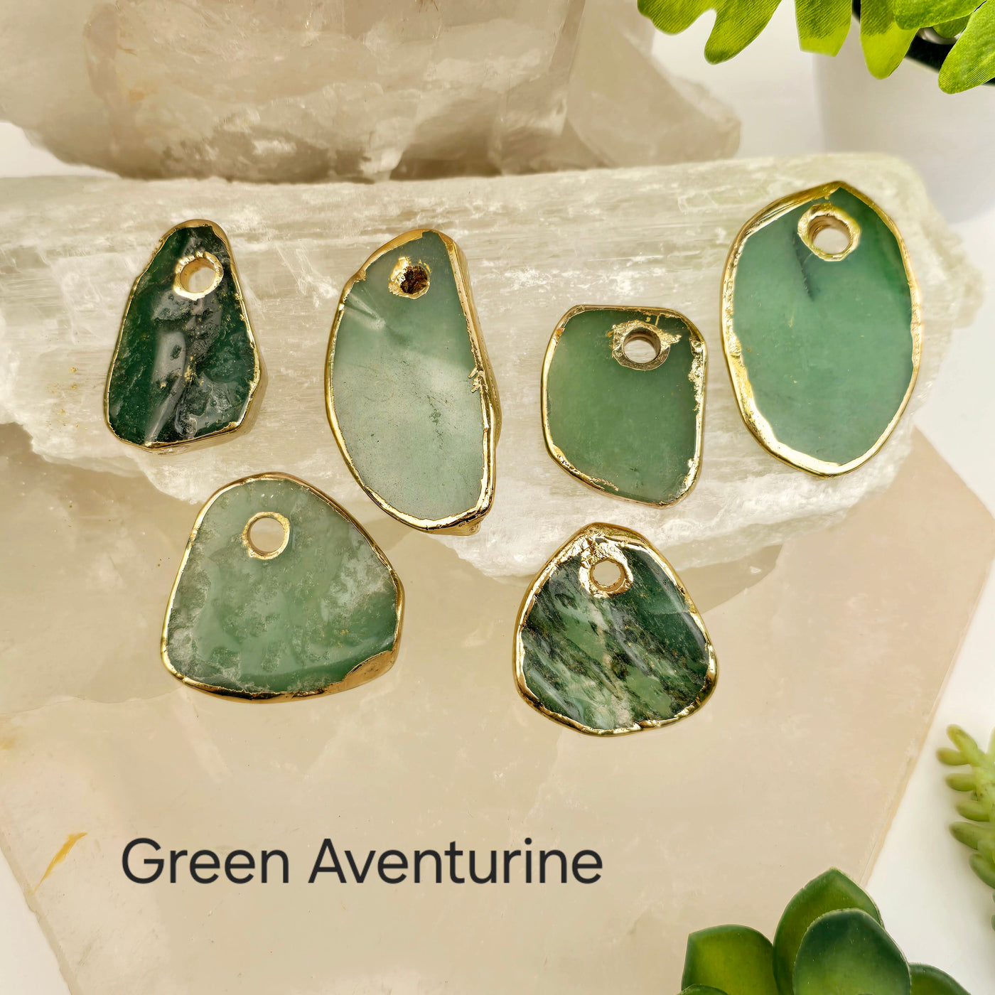 Crystal Freeform Slice Pendant with 24k Gold Electroplated Edges Top Front Drilled - You Choose Stone - green aventurine variant labeled on stone platters with props and plants in the background