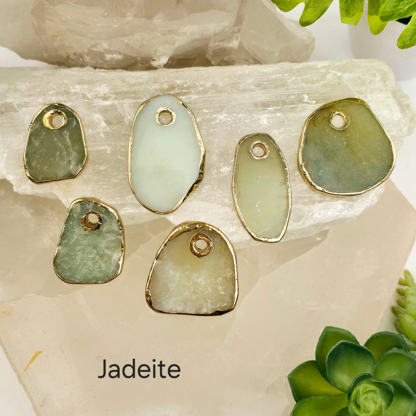 Crystal Freeform Slice Pendant with 24k Gold Electroplated Edges Top Front Drilled - You Choose Stone - jadeite variant labeled on stone platters with props and plants in the background