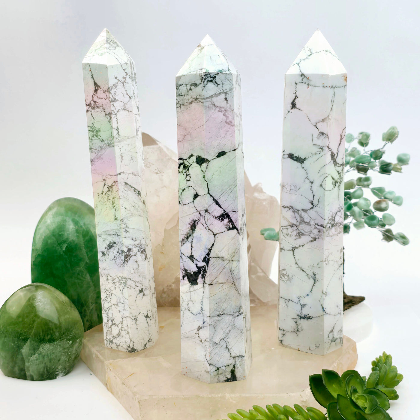 White Howlite Angel Aura Crystal Obelisk - You Choose all variants on stone platter with plants and props in the background