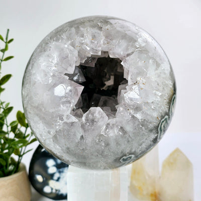 Light Amethyst Large Crystal Sphere One-of-a-Kind front view with props and plants in the background