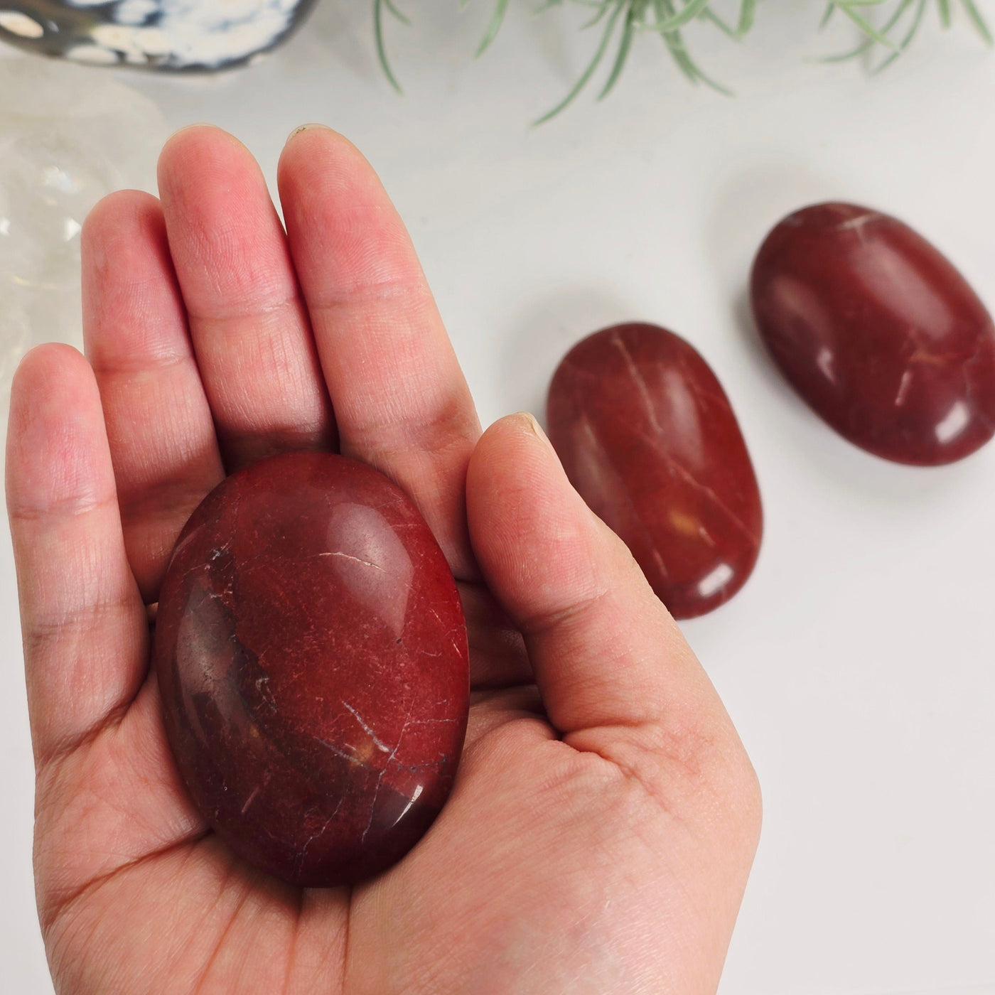 Red Jasper Crystal Palm Stone - You Choose variant 1 in hand for size reference with other variants in the background