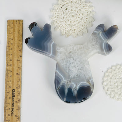 Agate reindeer in shades of gray and white. with a ruler next to it.