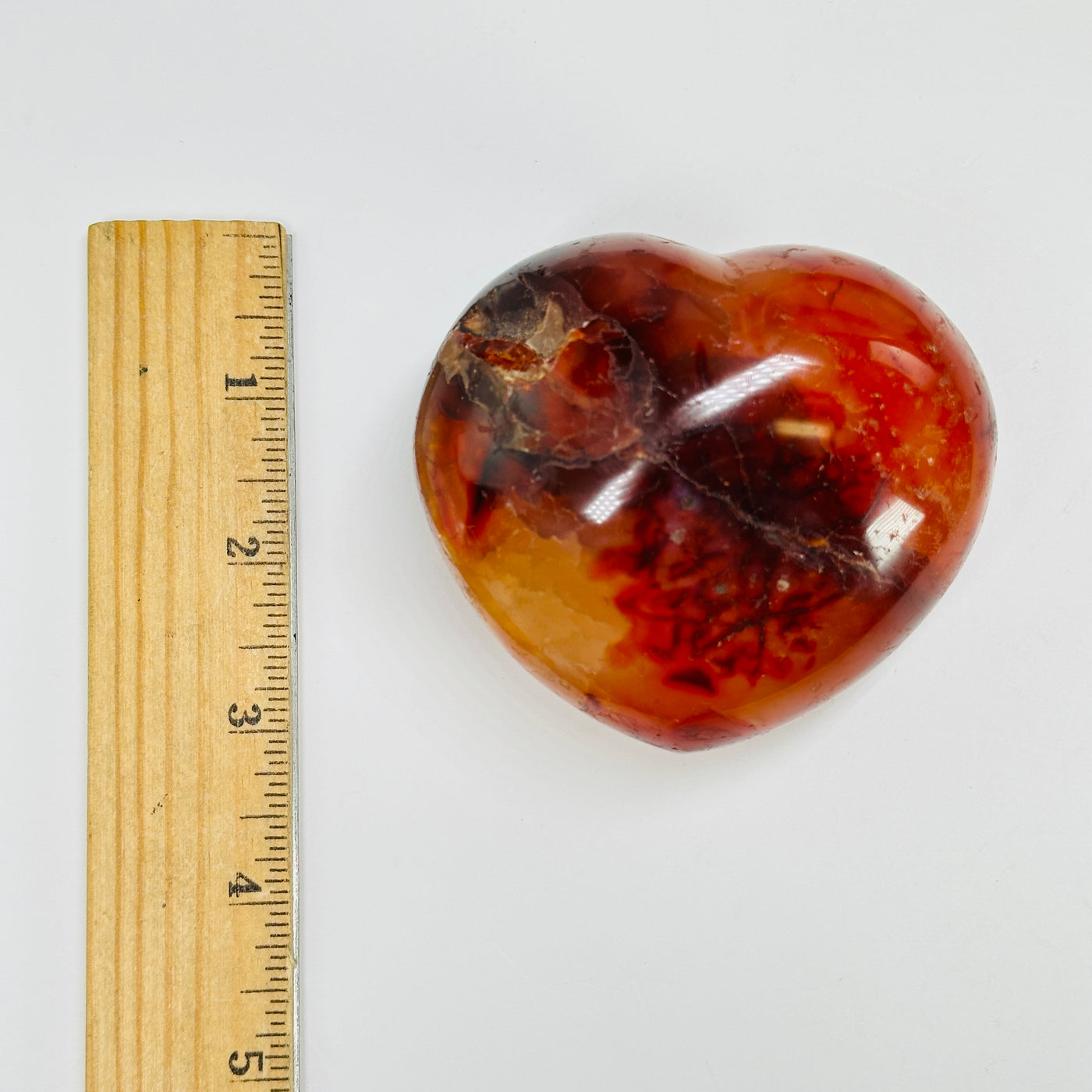 carnelian heart next to a ruler for size reference