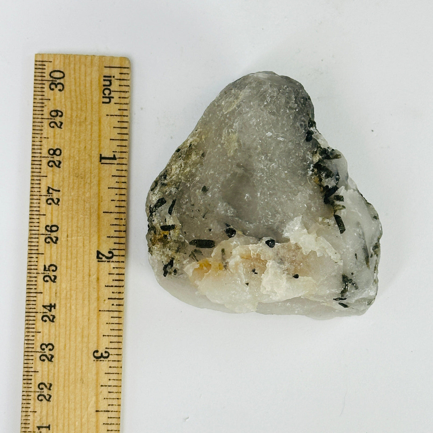 epidote on matrix next to a ruler for size reference