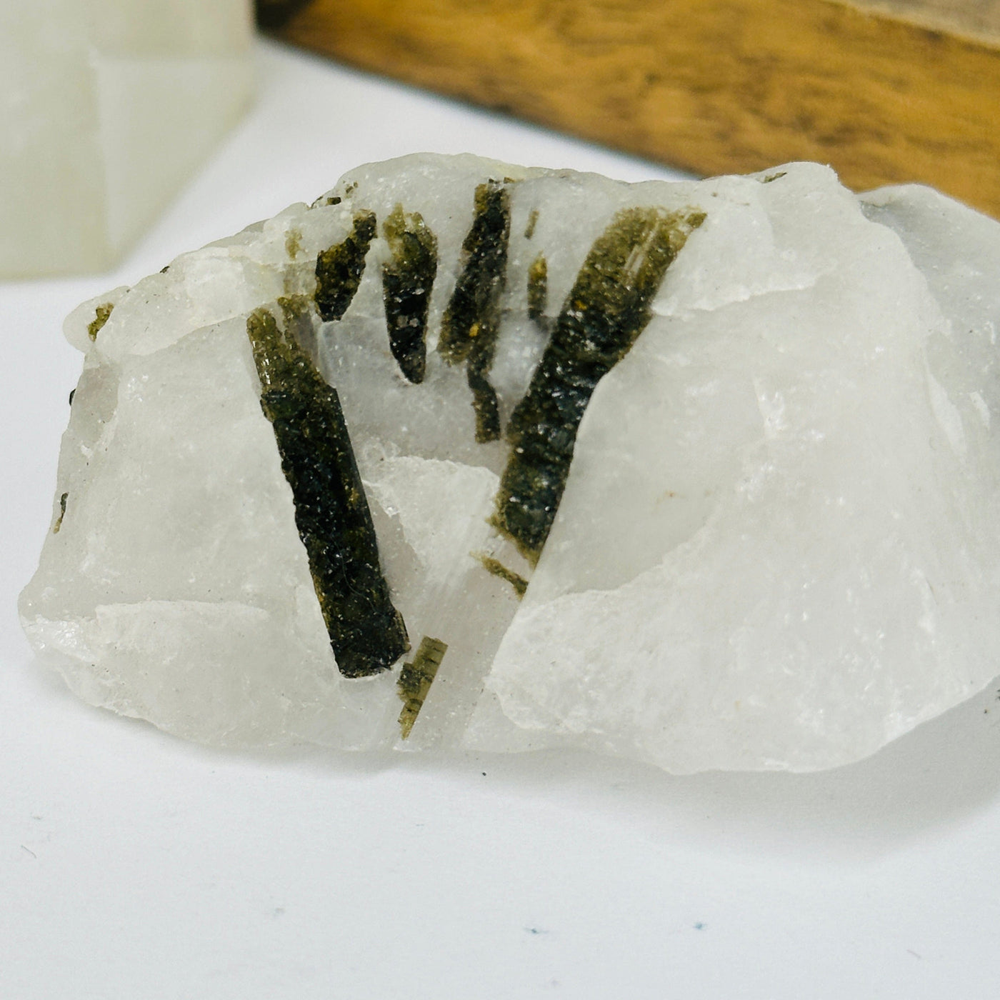 epidote on matrix with decorations in the background