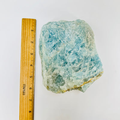 aquamarine next to a ruler for size reference