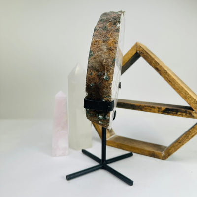 pink amethyst on metal stand with decorations in the background