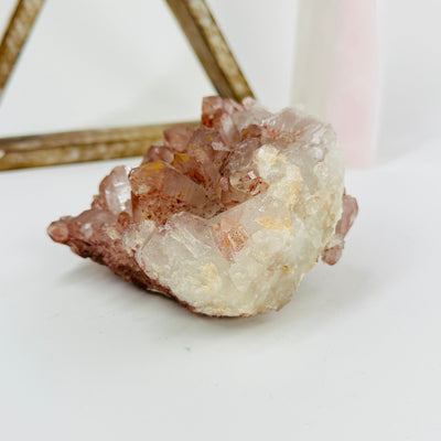 side view of lithium quartz cluster with decorations in the background