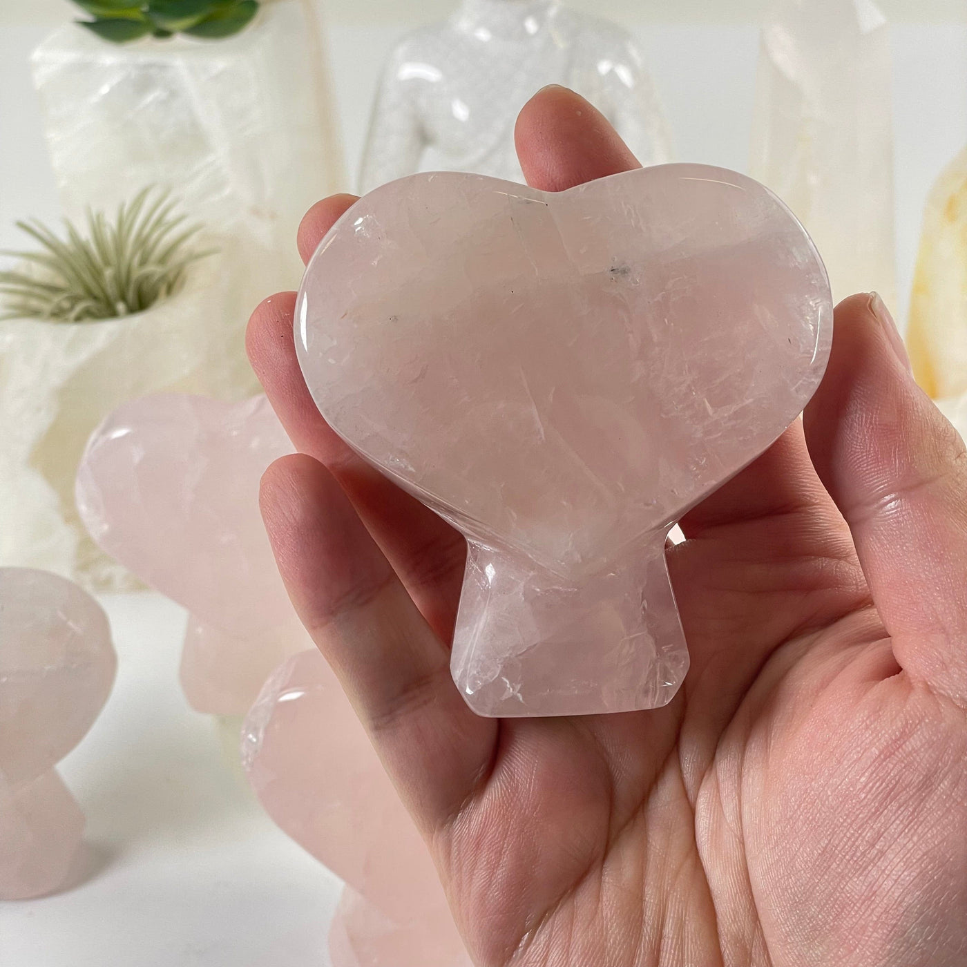 Rose Quartz Crystal Heart on Stand - You Choose one in hand for size reference with others in the background
